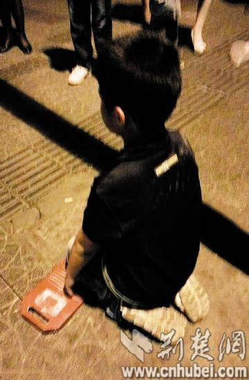 武汉一小学生没写作业 被父母惩罚当街跪搓衣板